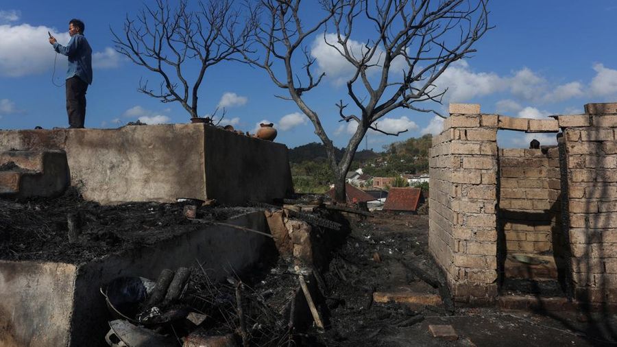kebakaran-desa-adat-sade-lombok-tengah-02-puing-udara-Foto=Reuterscnbcindonesia Warga berdiri di atas reruntuhan rumah adat Sade yang hangus akibat kebakaran di Lombok Tengah