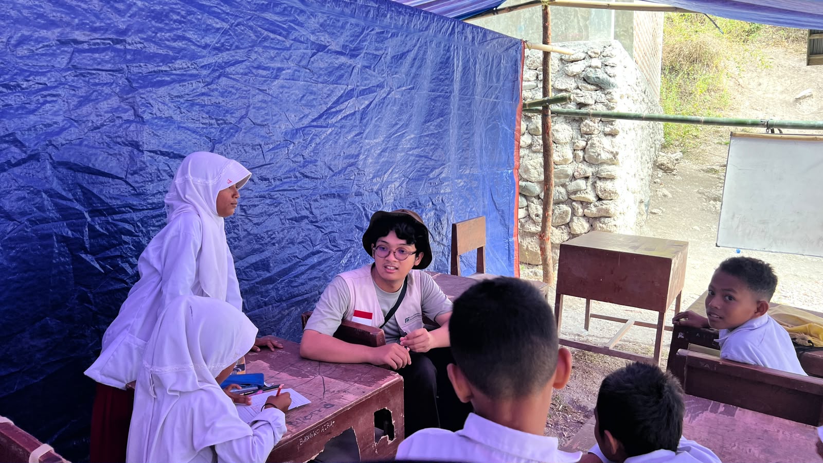 kegiatan-belajar-di-sekolah-darurat-tenda-relawan-nusantara Siswa MIS Mujahidin Arabi mengikuti kegiatan belajar mengajar di dalam kelas darurat beratap tenda.