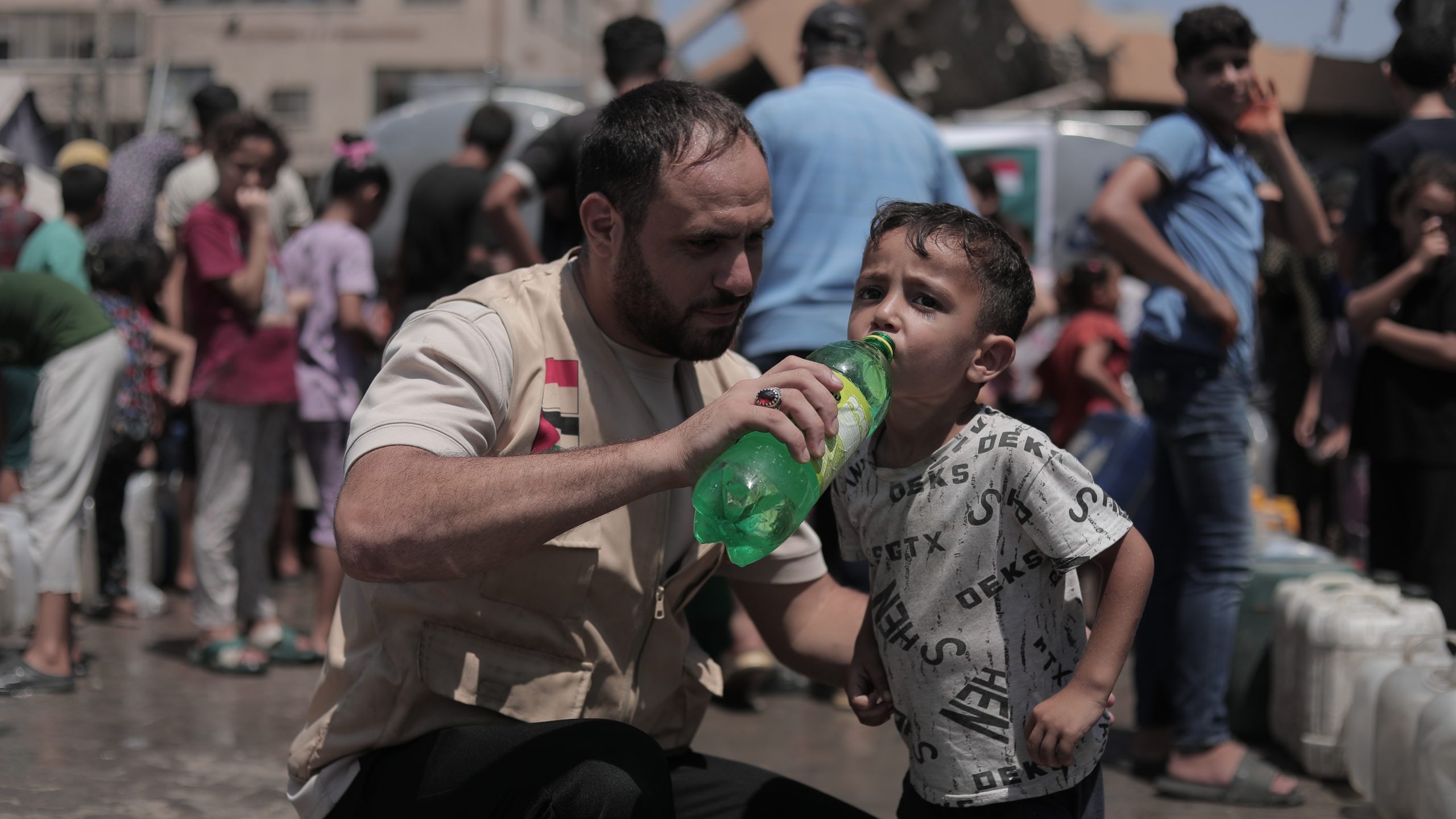 relawan-nusantara-memberikan-air-minum-bersih-anak-gaza Petugas relawan nusantara meminumkan air bersih layak konsumsi kepada seorang anak di Gaza.