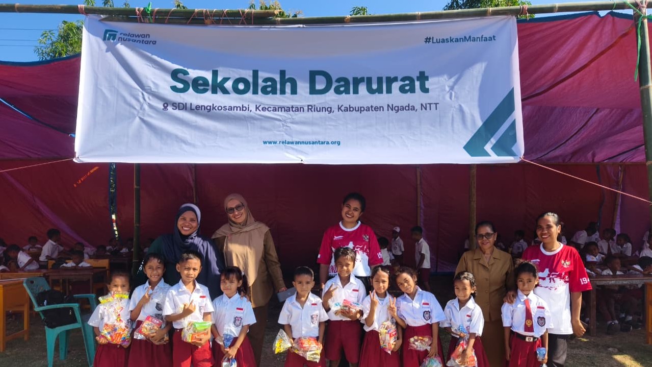 Siswa dan guru foto bersama di depan spanduk sekolah darurat SDI Lengkosambi buatan Relawan Nusantara.