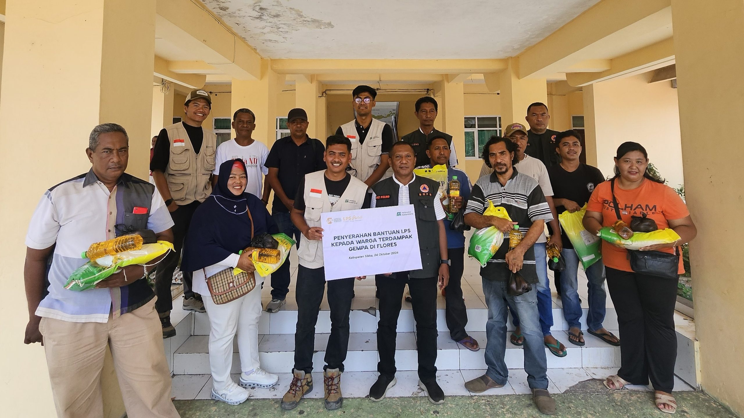 Penyerahan simbolis bantuan gempa bumi Sikka berupa paket sembako dari LPS dan Relawan Nusantara bersama penerima manfaat di NTT.