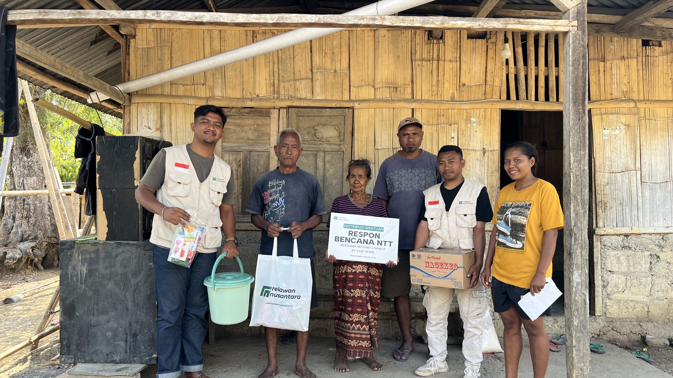 bantuan-kemanusiaan-second-chance-evie-home-desa-nili-waru-sae-ngada-relawan-nusantara Penyerahan simbolis paket bantuan sembako dan perlengkapan sanitasi dari Second Chance by Evie Home bersama Relawan Nusantara kepada keluarga penyintas gempa di Desa Nili Waru Sae.